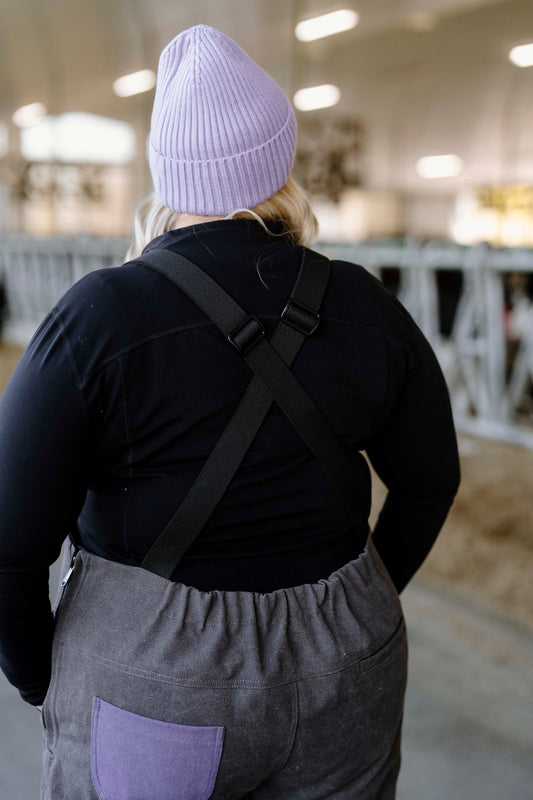 Person in purple toque with grey overalls on