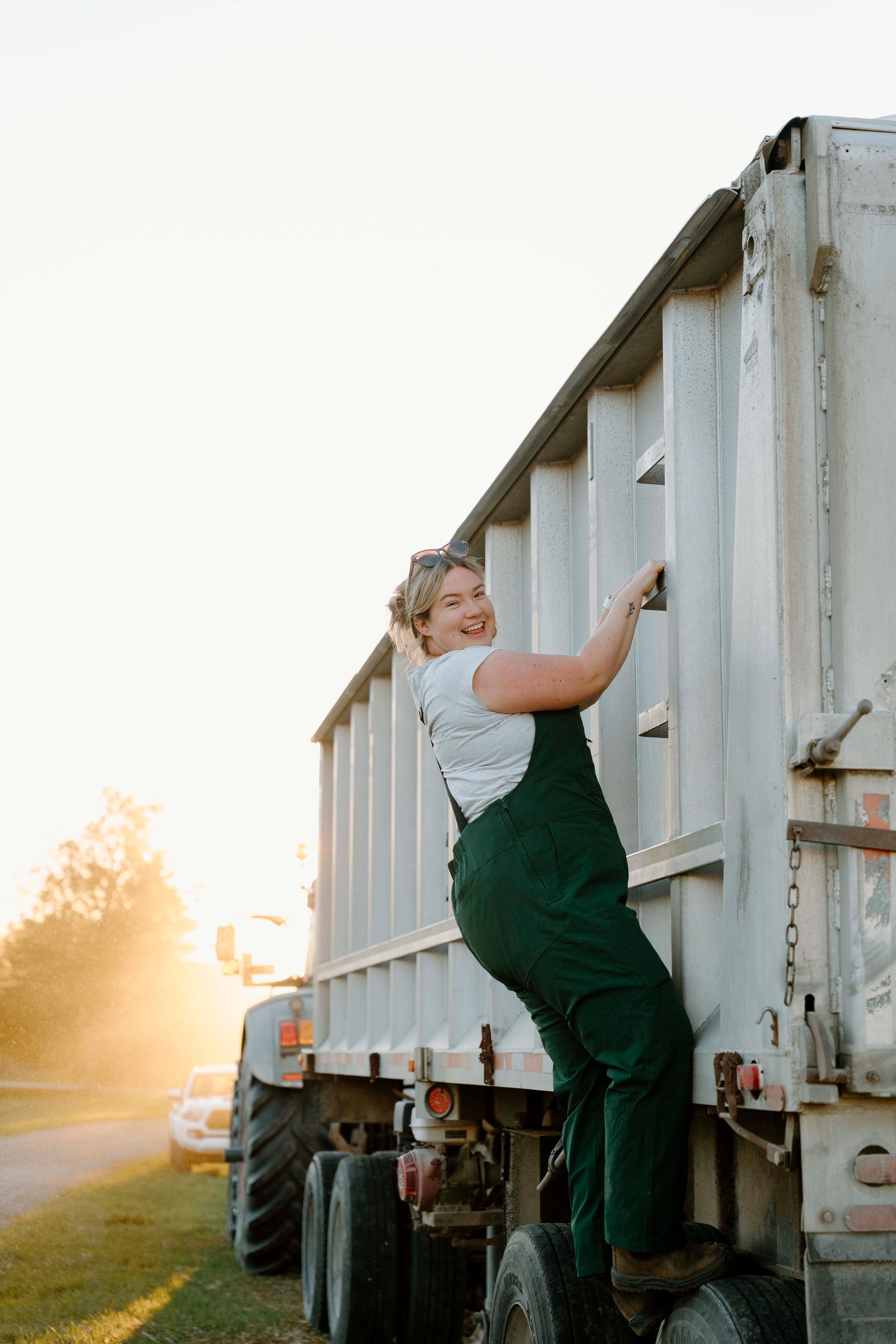 Person climbing into a large white truck on a sunny day