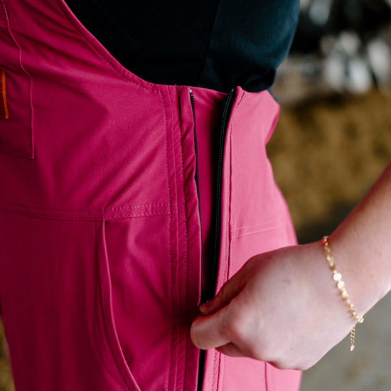 Person wearing pink overalls with a blurred background