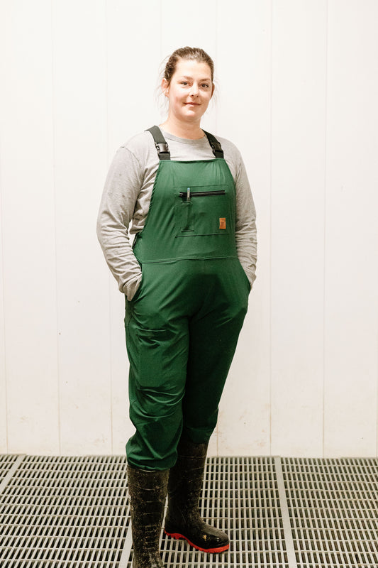 Lady standing in green overalls 